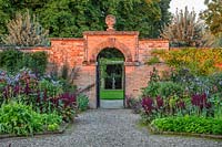 Gate in walled kitchen garden with beds of Amaranthus - Morton Hall Gardens, Worcestershire
