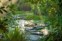 Stepping stones over pool in morning light, Worcestershire