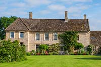 View to English period house with expanse of lawn. 
