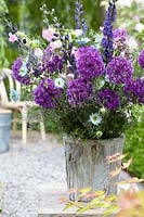 Mixed floral arrangement featuring Alliums in wooden container.