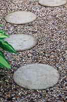 A stepping stone pathway in gravel. 