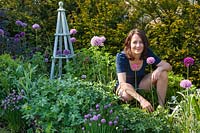 A portrait of Dan Isaac, working in her garden at Hail Weston.