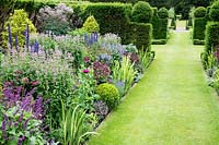 Herbaceous borders with grass path and clipped Taxus hedging, Scotland 