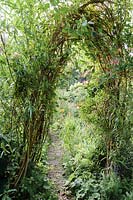 A woven willow arch with path running through. 