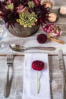 Place setting with dark red dahlias, hydrangeas and succulents