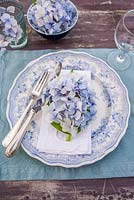 Table setting with blue hydrangea flowerheads