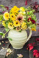 Yellow themed flower arrangement in old pottery vase -Calendula officinalis, fennel flowers, sunflowers and nasturiums