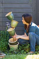 Arranging and balancing ceramic pots around central pole