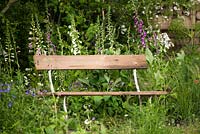 Wooden bench set amongst Digitalis purpurea - foxglove. 'The Welcome to Yorkshire Garden', RHS Chelsea Flower Show 2017. 