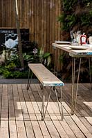 Industrial style outdoor dining area with table and bench. 