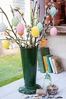Container of Salix discolor - pussy willow - with hanging easter eggs. 