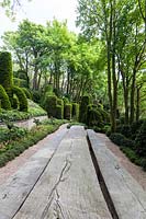 Table and oak benches by Thomas Rosler in the Jardin D'Aval with Muehlenbeckia complexa. Les Jardins D'etretat, Normandy, France. 