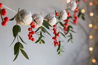 Painted walnuts strung on thread with Ilex berries and Eucalyptus. 