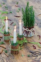Festive candle holders and centrepiece made from cinnamon sticks, rosemary, dried chillis and ribbon. 
