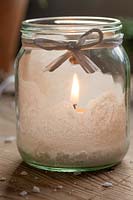 Close up detail of festive salt frosted candle jar. 