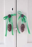 Pine cone decorations hanging cupboard door knobs. 