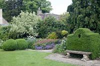 Topiary and perennial borders at Barnsley House, Cirencester, UK.