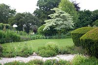 Topiary and perennial borders at Barnsley House, Cirencester, UK.