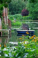 Moat with rowing boat. Inula magnifica and Lychnis - Loosestrife. 