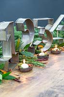 Advent table decoration with large metal number cake tins and small white candles