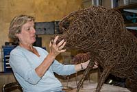 Helen Colletta working on a willow pig sculpture in her studio, Suffolk