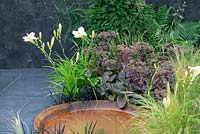 Creamy Hemerocallis with Sedum 'Matrona' and Ophiopogon planiscapus 'Nigrescens' next to a rust effect shallow pool - A Place to Ponder, RHS Tatton Park Flower Show 2018