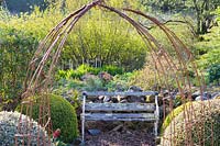 Rusted steel frames create an archway at the centre of the Rickyard garden, framing a seat amongst clipped evergreen shrubs.
