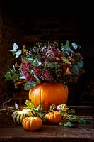 Pumpkin vase with flowers and foliage