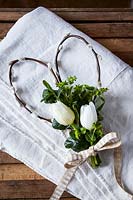 Spring floral arrangement with willow stem heart with white Tulips, greenery and ribbon