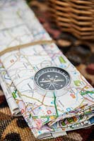 Close up of map and compass on picnic blanket