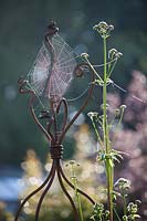 Spider web on a wrought iron plant support