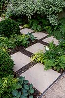 Paving slabs and shade tolerant planting with Dryopteris, Hakonechloa and Hostas