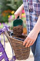 Adding compost to lined basket