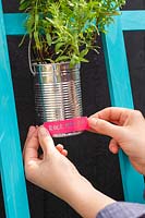 Adding brightly coloured tape to tin cans to use as name labels