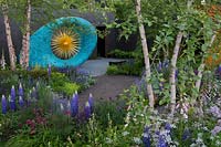 Sculpture surrounded by mixed planting in The David Harber and Savills garden, Sponsor: David Harber and Savills. RHS Chelsea Flower Show, 2018.