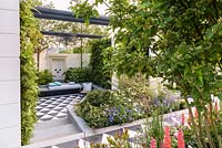 Courtyard with seating, black and white paving and pollution-absorbing planting including living-wall with Ferns - New West End Garden - Sponsor: New West End Company, Sir Simon Milton Foundation - RHS Chelsea Flower Show 2018 Gold