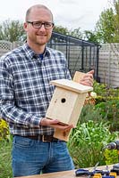 Man holding finished home made bird box designed for Blue Tits and other small birds