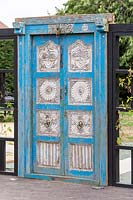 Decorative Indian door inset into black painted trellis