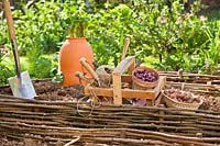 Tools and equipment needed for spring planting in vegetable garden.