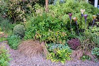 Border planted with mixed grasses and bamboo with glass flowers by Jenny Pickford - Shropshire, UK