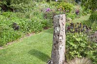 Standing stone in herbaceous, double-border at Dyffryn Fernant