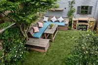 Courtyard garden with artificial lawn and reclaimed scaffold board seating, West London 