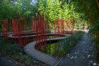 Tall bambooand winding pathways with red poles. Pres du Goualoup. Festival des Jardins 2018, Chaumont sur Loire, France  