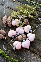 Pink heart baubles with cones and juniper berries