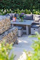 Modern lounge furniture on patio with gabion walls