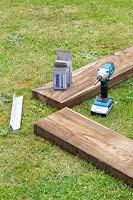 Tools and wood to create new raised bed edge. 