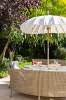 Dining furniture with umbrella on modern patio. 