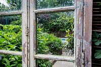 Reclaimed mirror with reflections of North London garden and patio.