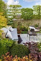 Pleached Carpinus Betulus and Cotswold stone walling with built-in seating. 'The Bovis Homes Family', RHS Malvern Spring Festival, 2018. 
