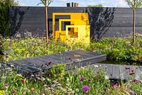 Yellow steel sculptural panels with black fence and meadow-style planting. 'Urban Oasis', RHS Malvern Spring Festival 2018.